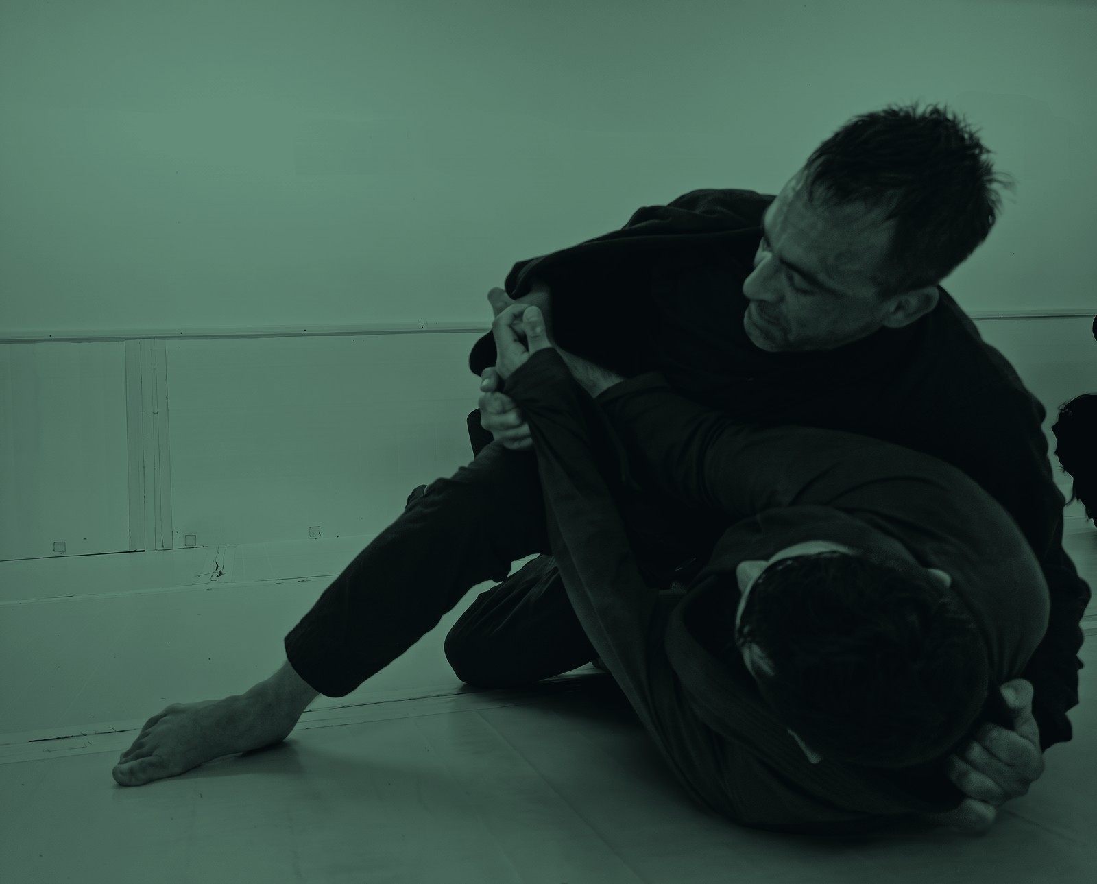 Two athletes grappling on BJJ mats